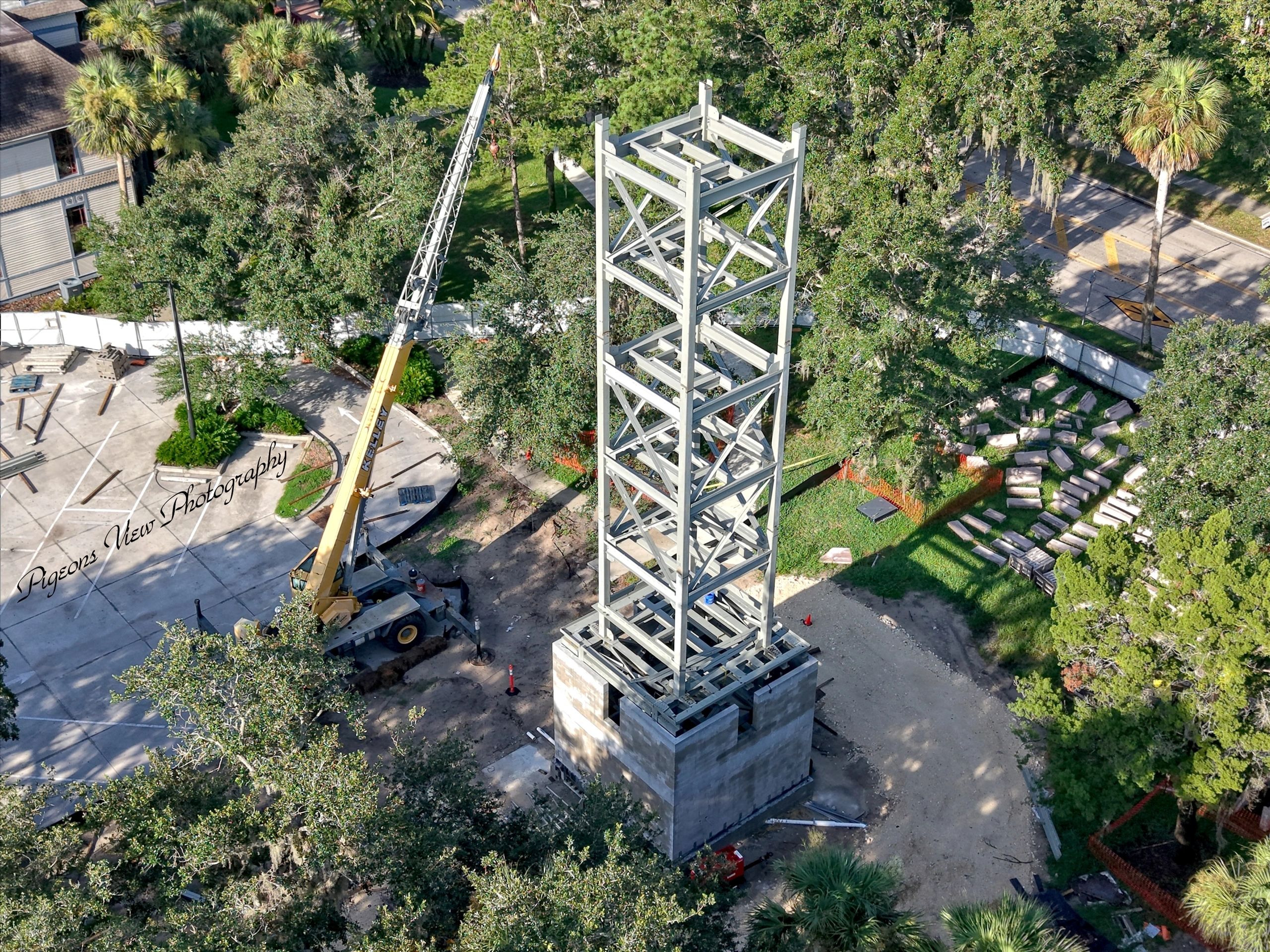 Tower structure surrounded by greenery and machinery