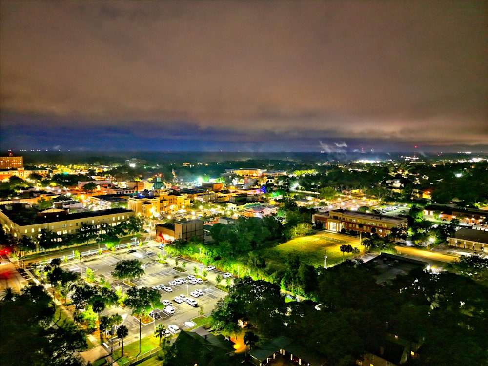 Illuminated urban landscape under cloudy sky