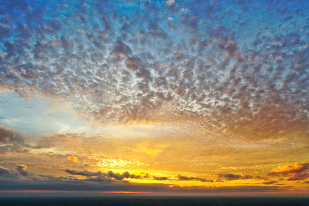 Vibrant sunset sky with scattered clouds.