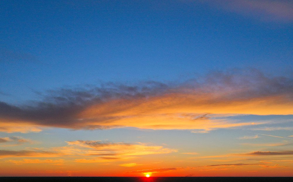 Sunset with vibrant orange and blue sky.