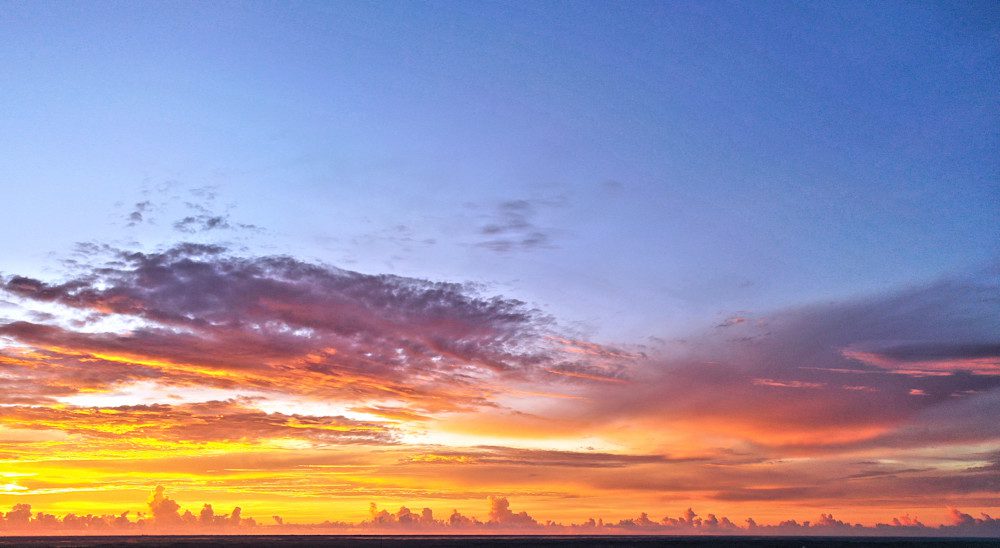 Sunset over horizon with clouds