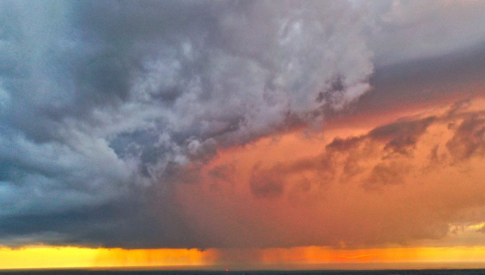 Vibrant sunset beneath dark clouds