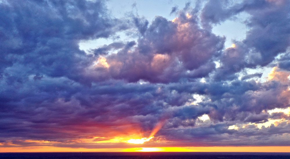 Sunset rays through cloudy sky