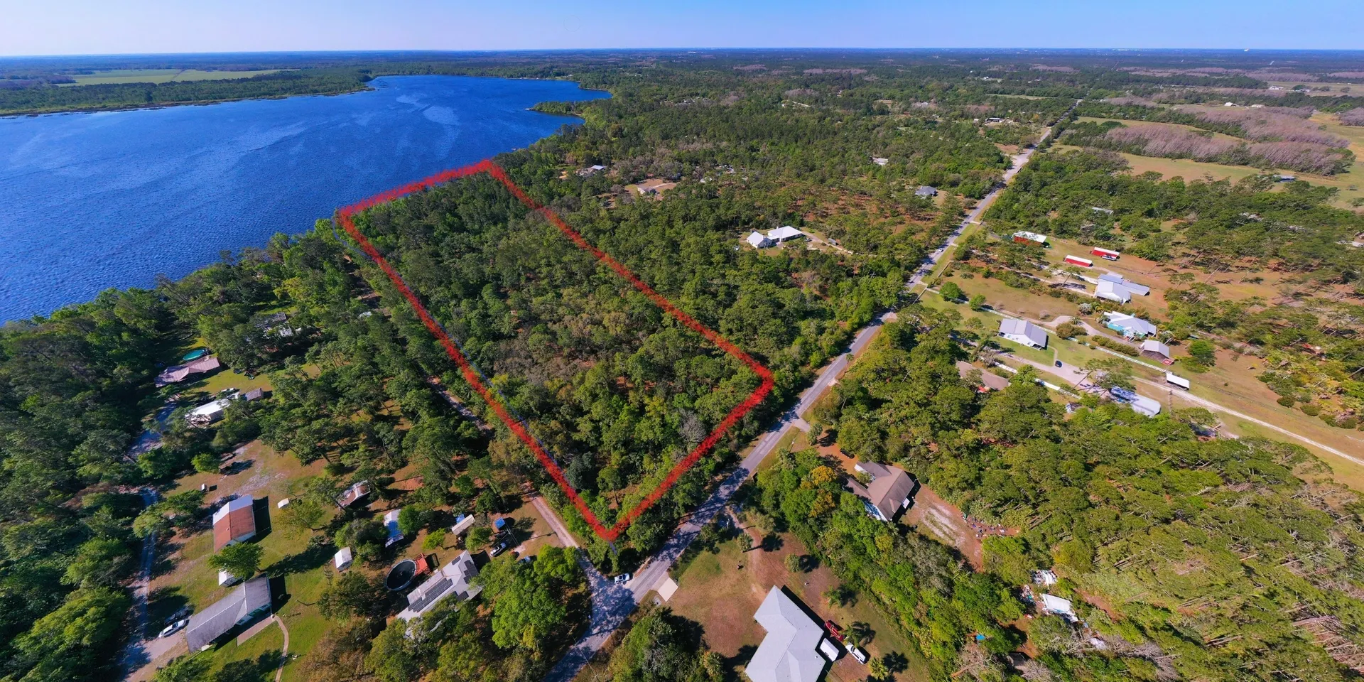 Red-outlined plot near water and trees