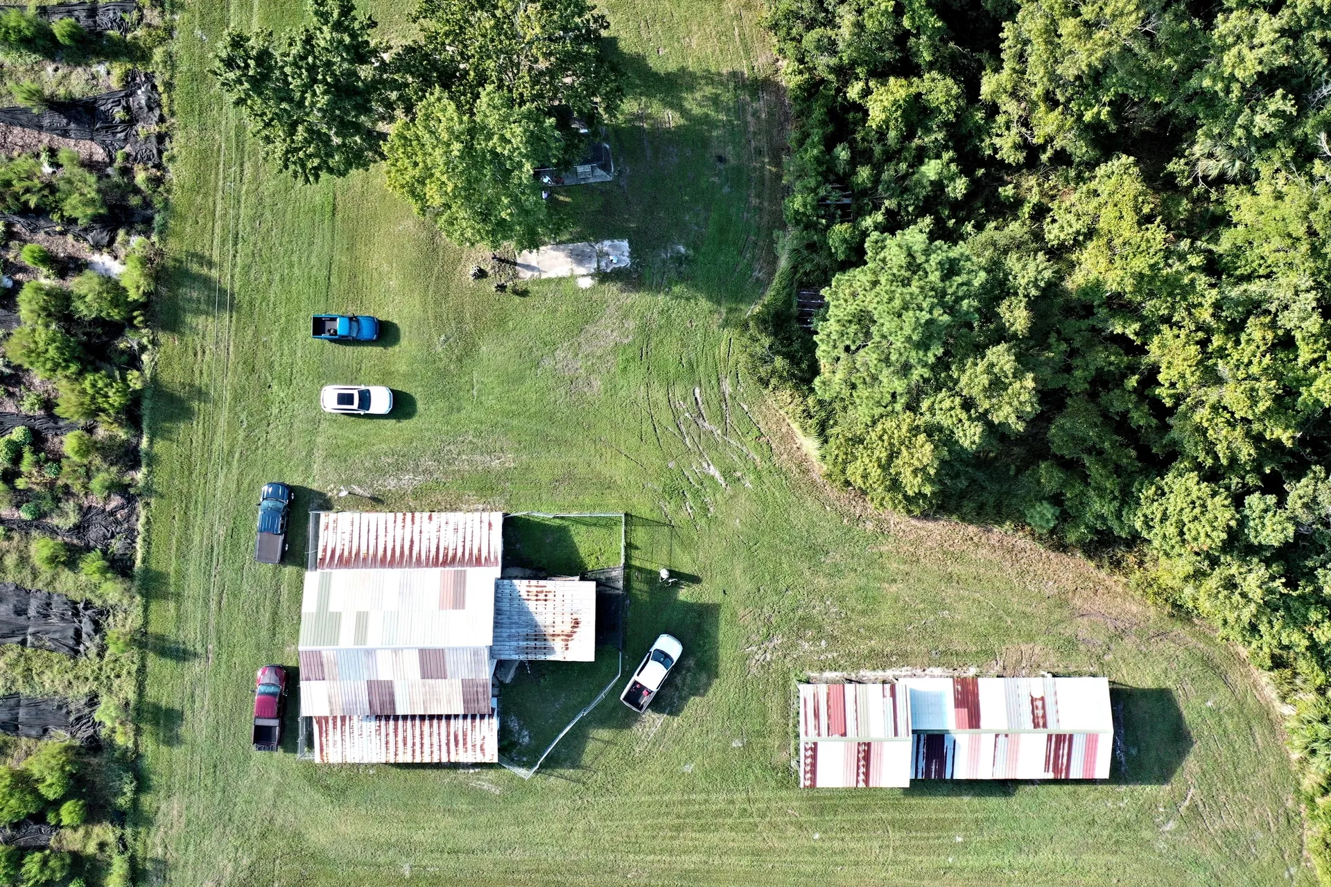 Aerial view of rural property and vehicles.