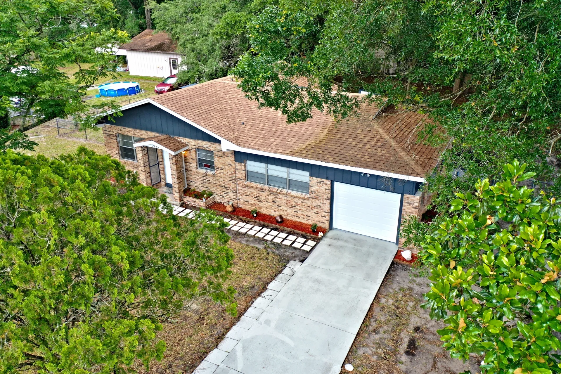 Brick house surrounded by green trees.