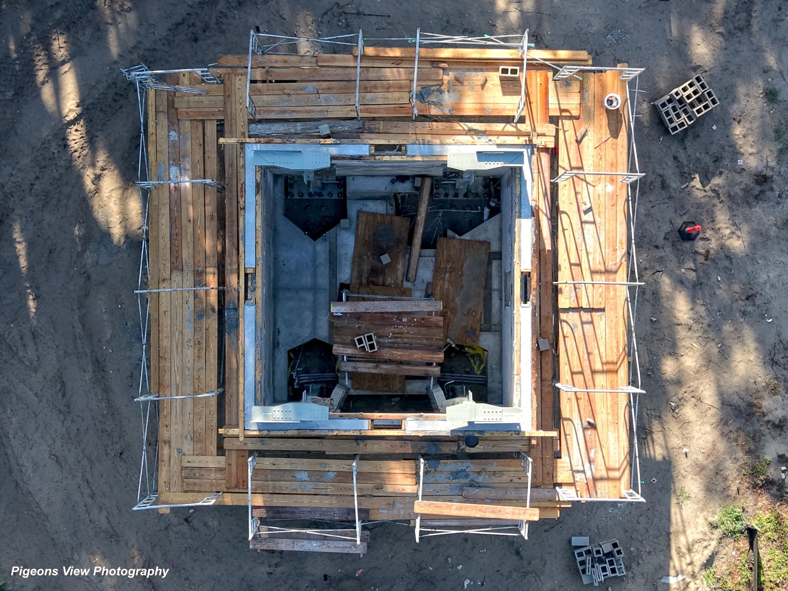 Square building foundation with scaffolding.