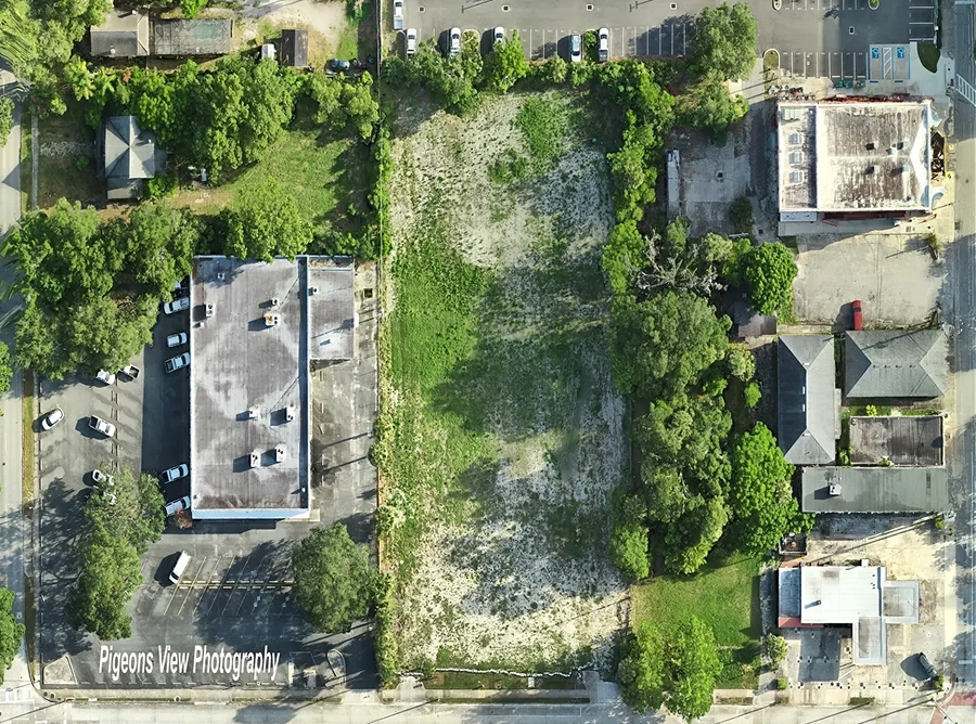 Empty plot surrounded by structures and trees