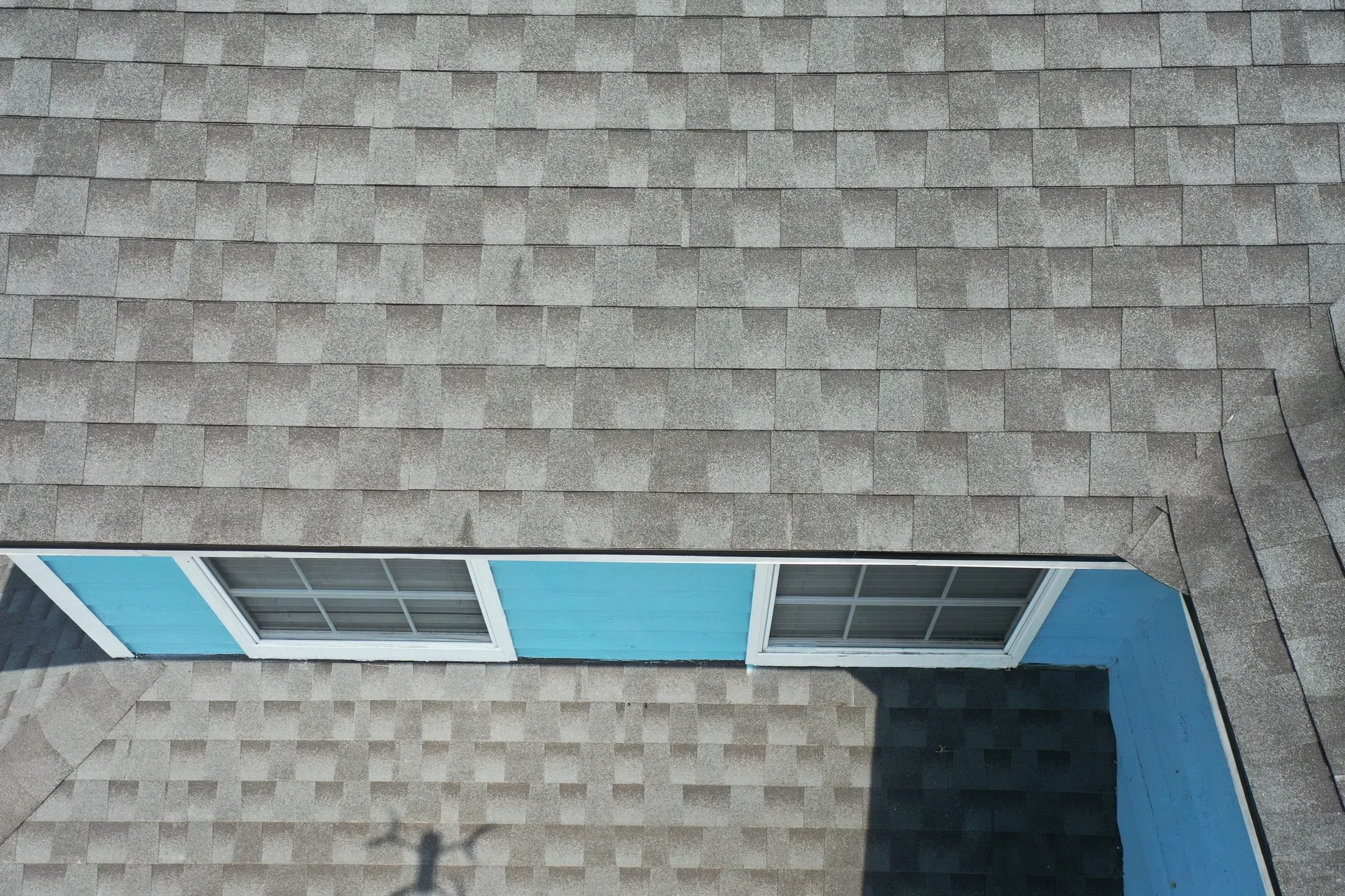 House rooftop with gray shingles and windows