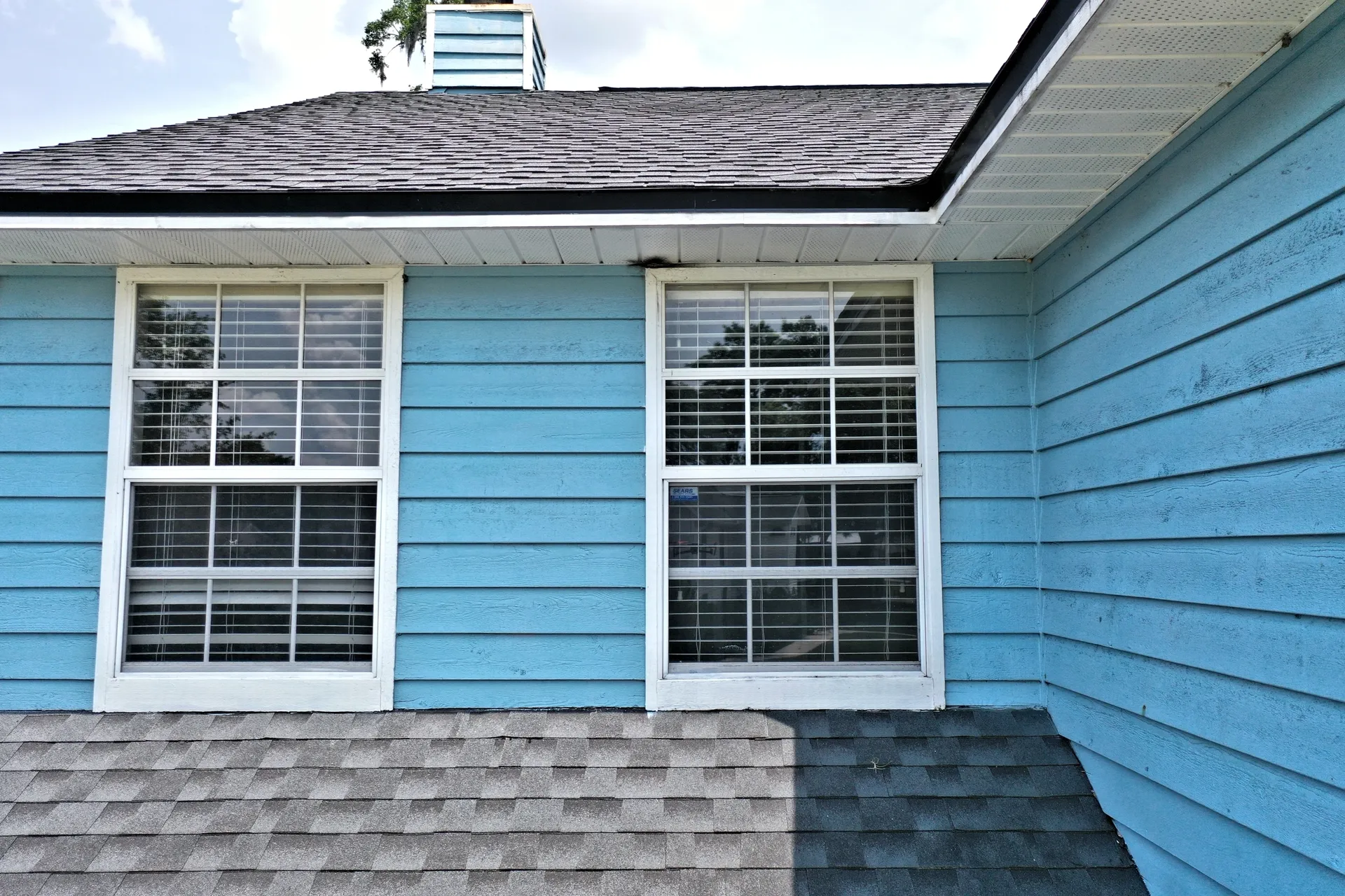 Two windows on a blue wooden wall