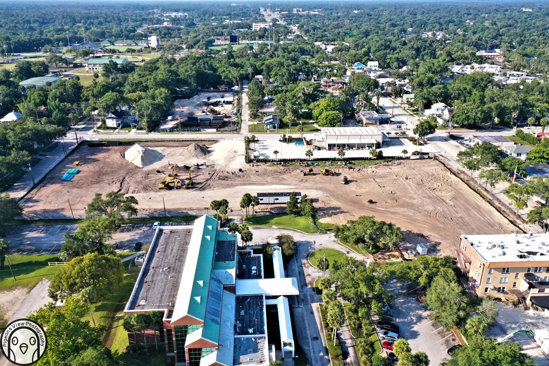 Aerial view of construction and nearby buildings.
