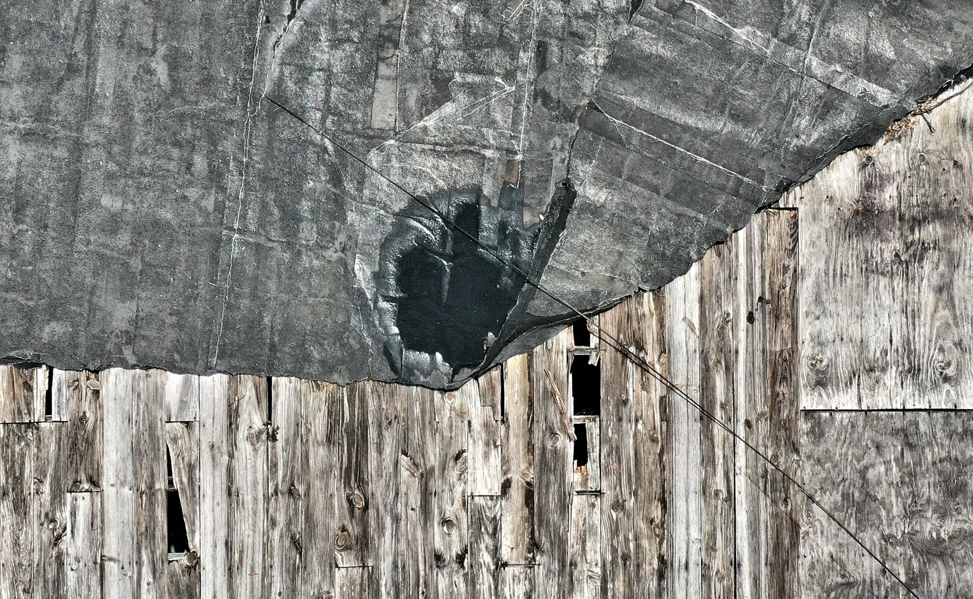 Weathered wooden barn with damaged roof