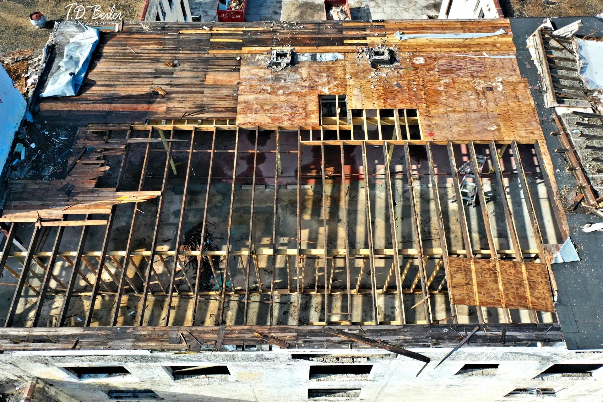 Partially repaired rooftop with visible framework