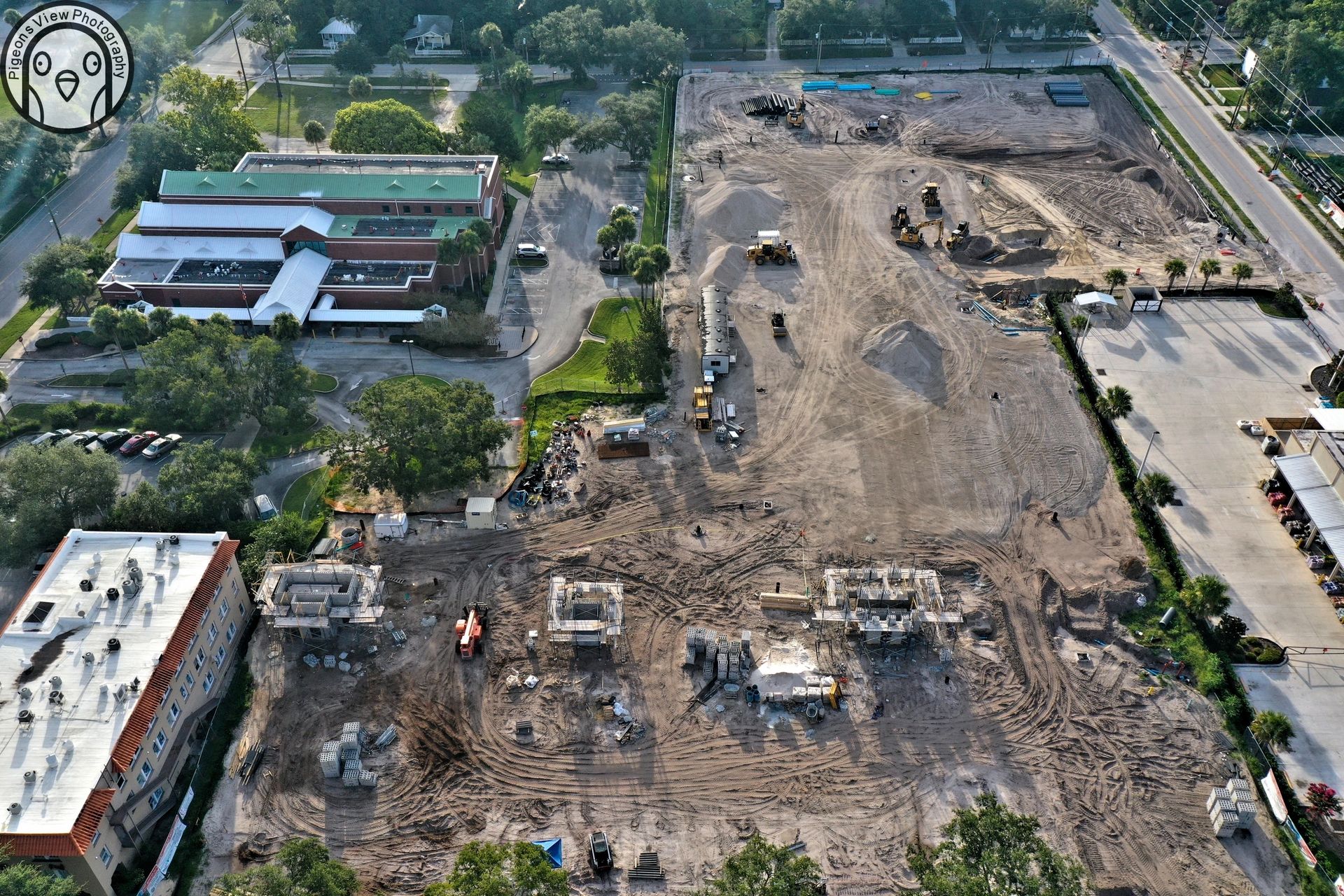 Building site surrounded by roads and trees.