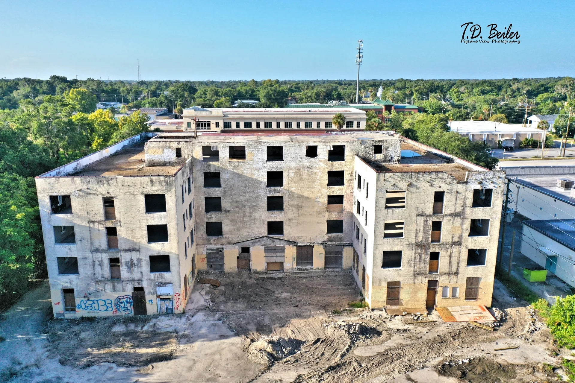 Large, empty building surrounded by trees