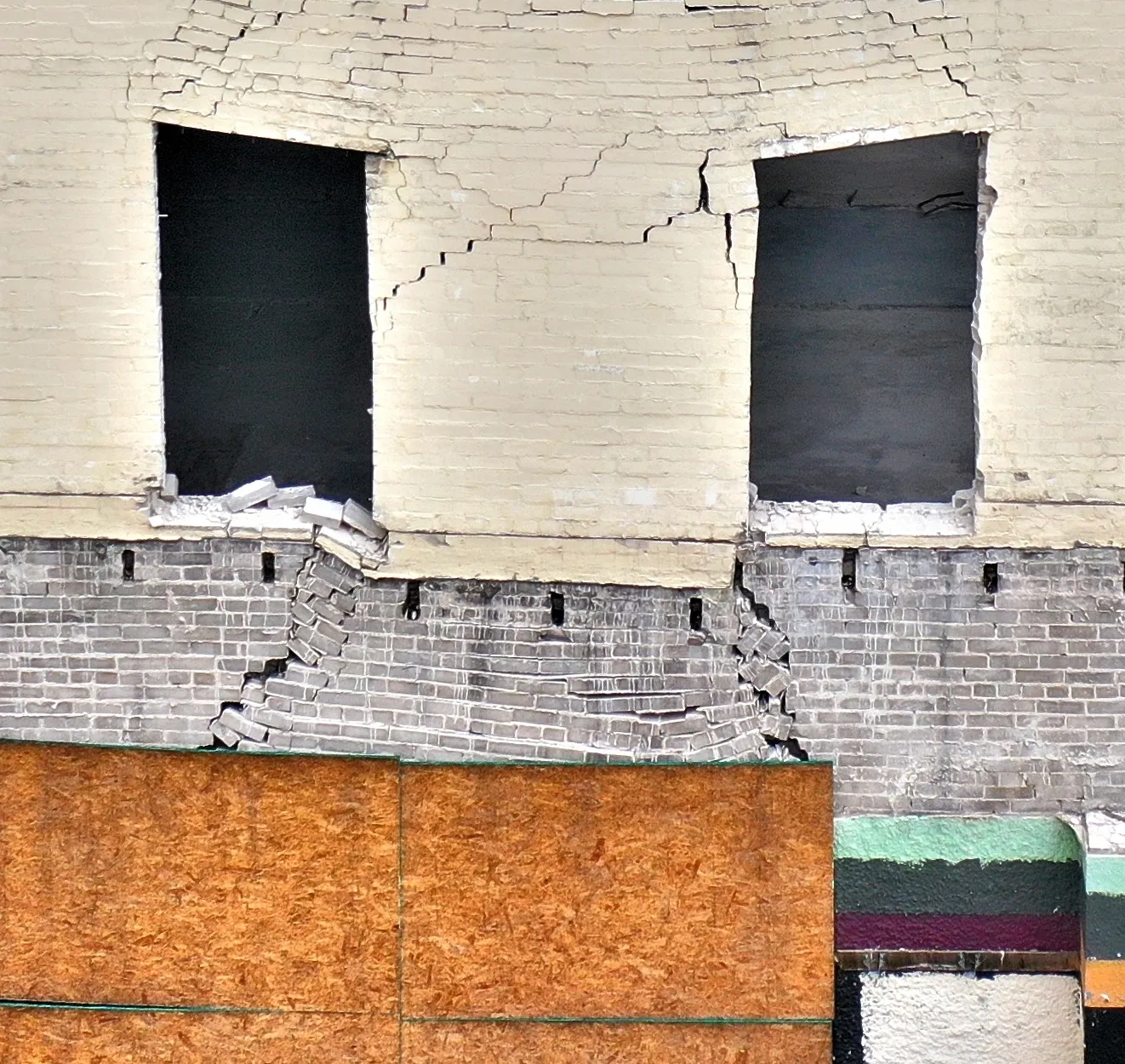 Damaged brick facade with cracks