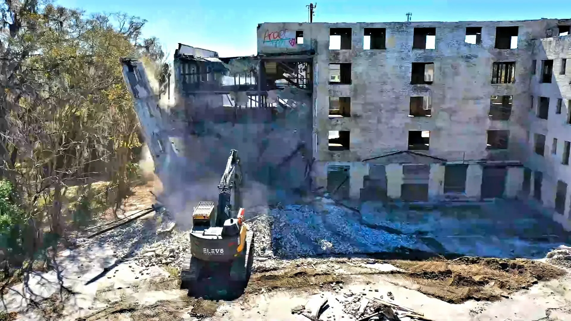 Building being demolished by machinery